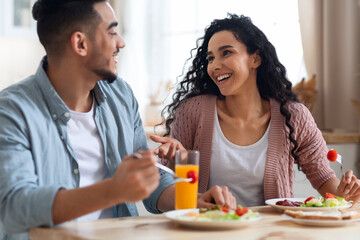 Morning Meal. Romantic Arab Couple Eating Breakfast, Chatting And Laughing In Kitchen