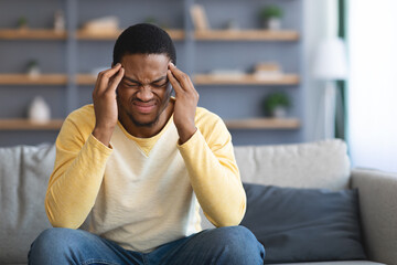Upset african american young man having headache