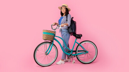 Asian lady holding retro bicycle with wicker basket