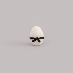 Creative Easter concept with broken white egg wearing black karate belt
