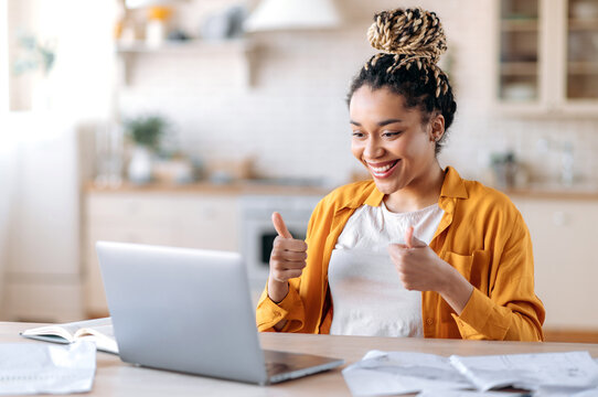 Successful confident beautiful african american girl, manager, freelancer or student, working remotely, chatting at online conference with colleagues, showing thumbs up, smiling friendly