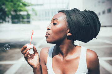 Young black woman playing bubble soap