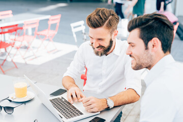 Two young businessmen using computer