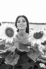 Beautiful brunette woman in a white top on the field with sunflowers. Yellow sunflowers. Close plan. Черно белая фотография