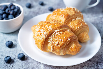 Fresh croissants with berries and cup of coffee