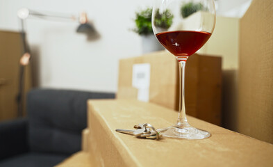 Keys and a glass of red wine in a new apartment.