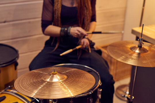 Close-up of woman holding sticks and playing drums during performing