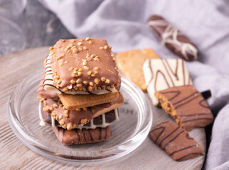 Cookies with chocolate and nuts on a glass plate. On a gray background. Close-up. 