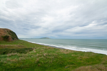 Green Cliffs at Te Waewae Bay with view of Pahia point at distance, The Catlins, Southland, New Zealand