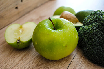 Apples, kiwi and avocado are on the table. Green color.