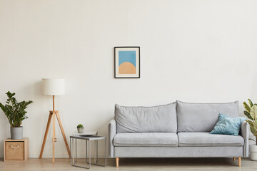Background image of minimal home interior with focus on comfortable sofa against white wall with abstract art, copy space