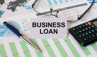 Business Card with text Business Loan with calculator white pen eyeglasses on the diagrams