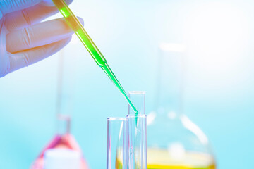 Chemical test tubes and pipette with green liquid close up in a chemical laboratory