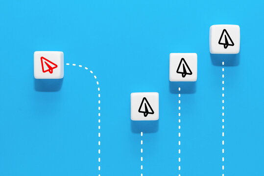A cube with the image of a red paper airplane icon that are different from the group, blue background, Business concept for new ideas creativity and innovative solution