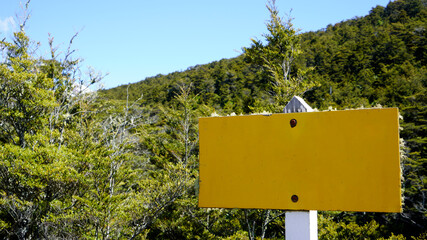 Yellow weathered sign in wooded area, Blank area for text