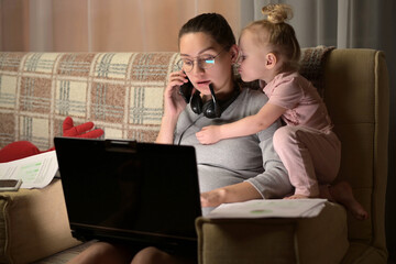 Young pregnant woman tries to work remotely, but her little daughter interferes - obrazy, fototapety, plakaty