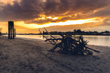 Stunning storm light, driftwood on beach long river