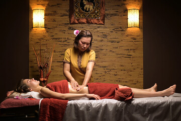 Thai massage session. Thai woman massage young beautiful woman