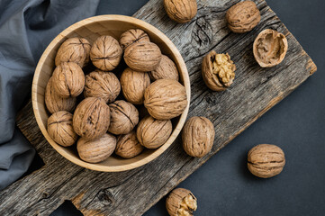 Ripe and raw whole big walnut kernel with shell on rustic backdrop. healthy nut food for brain
