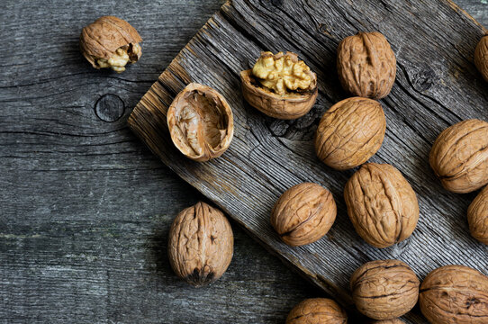 Ripe and raw whole big walnut kernel with shell on rustic backdrop. healthy nut food for brain