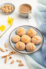Almond cookies and a cup of coffee on a white concrete background Side view.