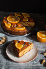 Orange cake on a gray wooden background. Hard light. Side view, close up.