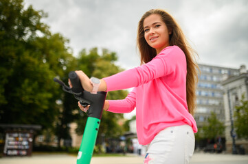 Young woman riding an electric scooter in the city