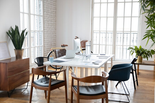 Empty Modern Loft Design Office With Computers And Gadgets On Table. Renovated Freelance Coworking Shared Workplace With Work Space Desk And No People. Company, Technology Concept.