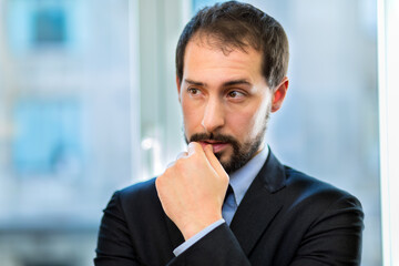 Thoughtful businessman portrait in his modern office