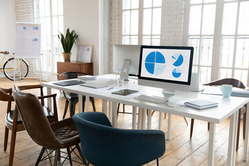 Empty modern office desk with PC and tablet paperwork on it. White table with electronic gadgets in...