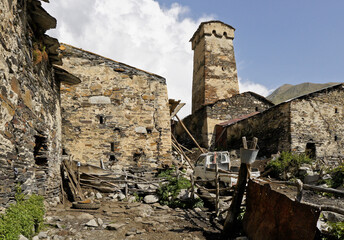 A medieval defensive tower rises above the more recent stone homes of Ushguli village, Upper...