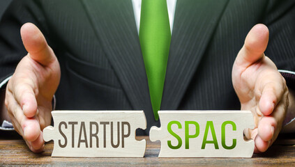 A man connects puzzles with the words Startup and SPAC. Simplified listing entry to stock exchange....