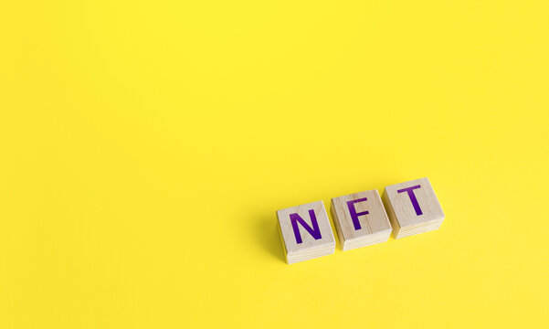 NFT non-fungible token word blocks. Selling digital assets and art through auctions. Monetization, investment in cryptographic tokens, cryptocurrency. Blockchain technology.