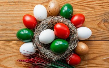 Easter eggs as the color of the Italian flag - green, white, red in nest.	Happy Easter holiday background