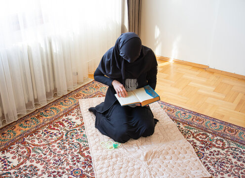The hijab muslim woman is reading the Quran and praying in the month of Ramadan. aid mubarak.