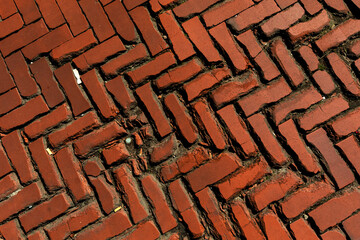 Old weathered and broken chipped brick road from naturally shiny brick pavement, clinker pavement texture
