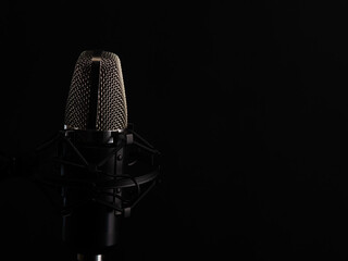 Microphone on a black background, singing and vocals, black background with space for an inscription or advertising
