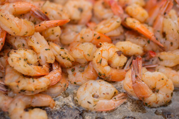 Process of grilling shrimps, prawns on brazier at summer local food market - close up view. Outdoor cooking, gastronomy, seafood, barbecue, street food concept