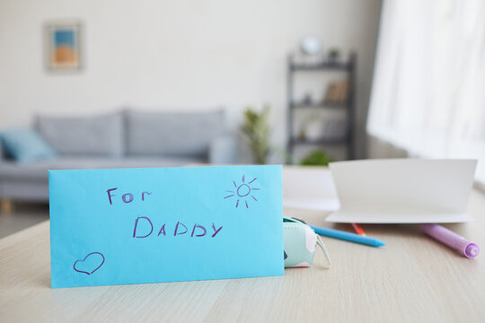 Minimal background image of blue envelope with letter for dad and handmade gift on Fathers day, copy space