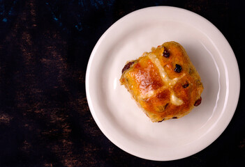 Top view of a hot cross bun on a plate