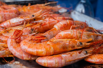 Close up: process of cooking fresh red langoustine shrimps, prawns on grill at summer local food market. Outdoor cooking, barbecue, gastronomy, seafood, cookery, street food concept