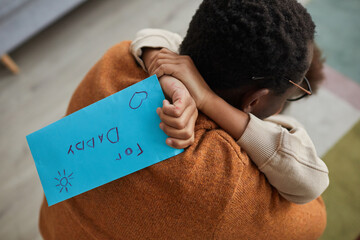 Close up of happy father embracing little girl after coming home from work on Fathers day, focus on...