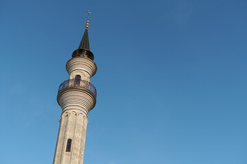 Minaret of the mosque against the blue sky. Islam in Europe
