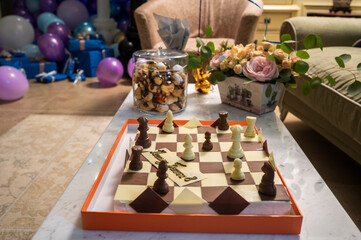 cake in the shape of a checkerboard and pastries on the table in the birthday celebration