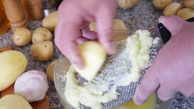 Closeup of Cooking otato pancakes draniki on grater . High quality FullHD footage