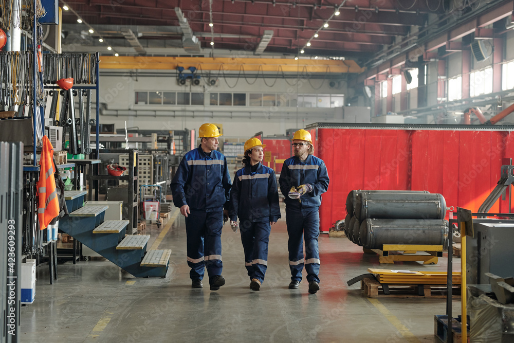 Poster group of workers or engineers of contemporary factory moving along large workshop with industrial eq