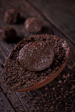 Chocolate Easter egg stuffed with brigadeiro on rustic wooden background. Image with selective focus.