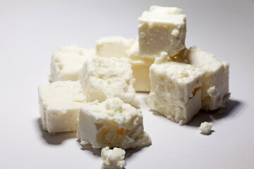 cubes of fresh sheep cheese on a light background