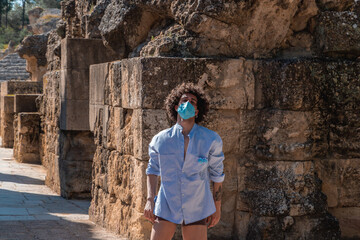 Spanish man with curly hairs wearing a mask and dancing barefoot