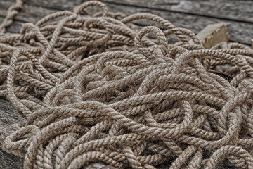 Fototapeta na wymiar beige long ropes stacked in heaps of sea tackle